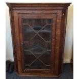 A small oak corner cupboard with bevelled glass. E