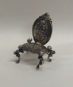 A silver doll's house carver chair with floral deco