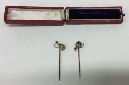 Two gold riding crop stick pins. Approx. 3 grams.