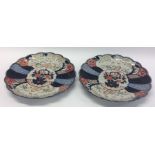 A pair of Imari circular wall chargers decorated w