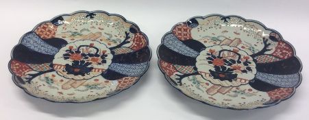 A pair of Imari circular wall chargers decorated w
