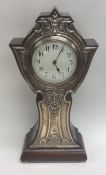 A tall Edwardian silver mantle clock decorated wit