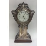 A tall Edwardian silver mantle clock decorated wit