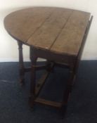 An Antique oak drop leaf table with plank top. Est