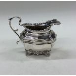 An Edwardian silver cream jug with floral decorati