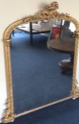 A massive gilt overmantle mirror decorated with sc