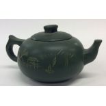 A Chinese green ground pottery teapot. Seal mark t