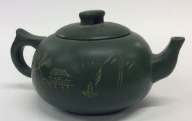 A Chinese green ground pottery teapot. Seal mark t