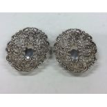 A pair of silver embossed dishes with pierced deco