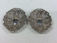 A pair of silver embossed dishes with pierced deco