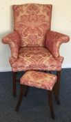 A pink upholstered armchair together with matching