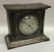 A silvered dial mantle clock on bracket feet. By W