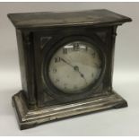 A silvered dial mantle clock on bracket feet. By W