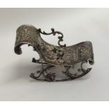 A novelty miniature silver rocking chair embossed