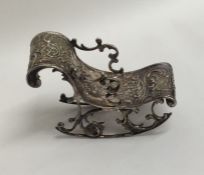 A novelty miniature silver rocking chair embossed