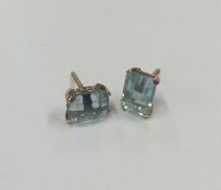 A pair of blue stone ear studs in gold claw mounts