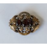 A cabochon garnet brooch. Approx. 11 grams. Est. £