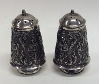 A pair of heavy Indian silver peppers decorated wi