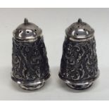 A pair of heavy Indian silver peppers decorated wi