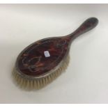 An Edwardian tortoiseshell and silver inlaid brush