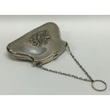 A silver purse decorated with musical instruments