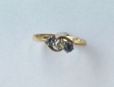 A sapphire and diamond three stone crossover ring.