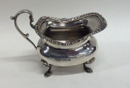 A heavy silver cream jug with gadroon rim. Sheffi