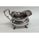 A heavy silver cream jug with gadroon rim. Sheffi