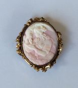 An Antique oval coral cameo of a lady in scroll fr