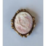 An Antique oval coral cameo of a lady in scroll fr