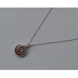 A stylish ruby and diamond swirl pendant with loop