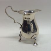 An Edwardian silver cream jug with card cut rim. S