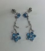 A pair of diamond and blue topaz earrings of flowe