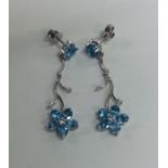 A pair of diamond and blue topaz earrings of flowe