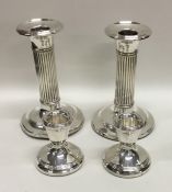 A pair of silver fluted dwarf candlesticks on spre