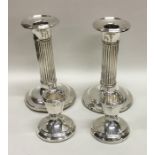 A pair of silver fluted dwarf candlesticks on spre