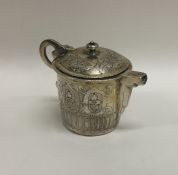 An Antique silver gilt jug with hinged cover decor