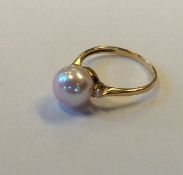A pearl and diamond three stone ring in 9 carat mo