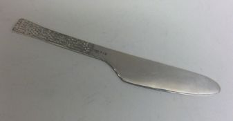 A heavy modernistic silver butter knife with textu
