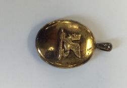 A silver gilt oval locket mounted with a sphinx wi