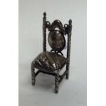 A miniature silver doll's house chair with swirl d