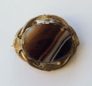 An oval banded agate brooch with leaf decorated fr