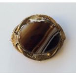 An oval banded agate brooch with leaf decorated fr