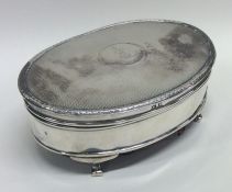 A silver hinged top jewellery box with engine turn