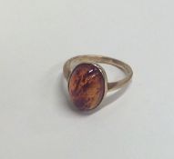 An amber single stone ring in rubover mount. Appro