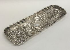 A heavy embossed silver pin tray with wavy edge. A