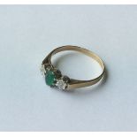 A 9 carat emerald and diamond three stone ring. Ap