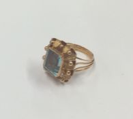 An 18 carat gold blue stone ring with reeded band.