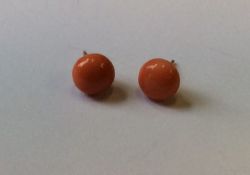 A pair of coral and gold mounted ear studs. Approx