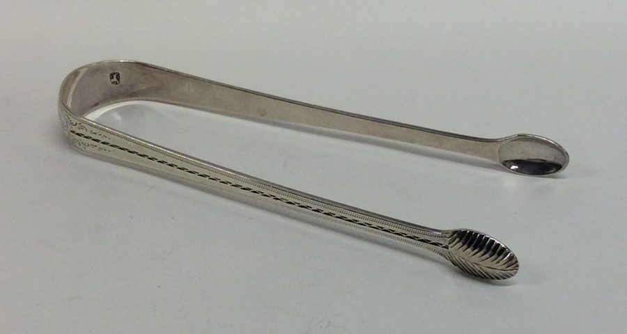 A pair of Georgian bright cut silver sugar tongs w